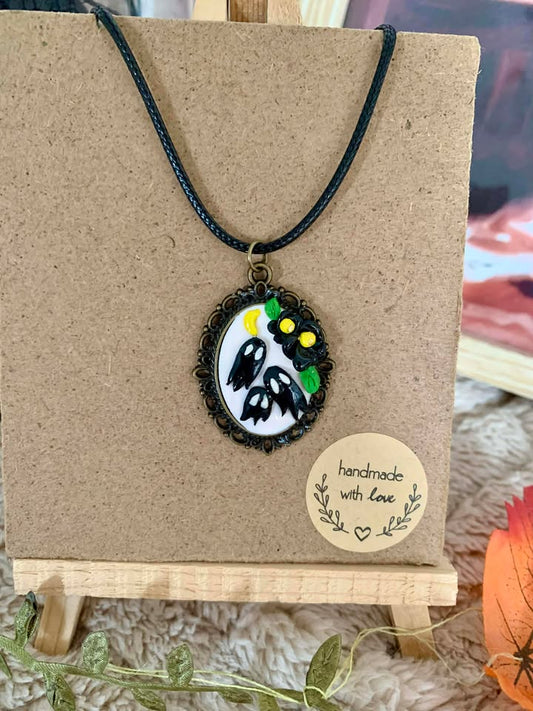 Vue rapprochée du Collier Fantômes Baroque, mettant en valeur le détail du médaillon hanté, accessoire captivant fait main par Jessica Deelyah.