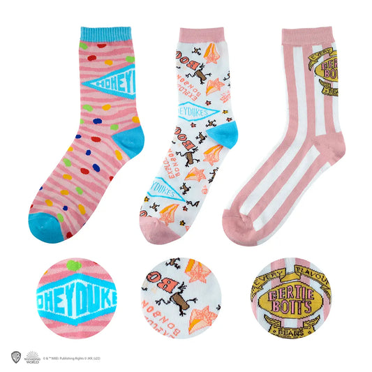 Lot de 3 Paires de Chaussettes Honeydukes - Harry Potter, montrant des motifs colorés inspirés de la confiserie magique.