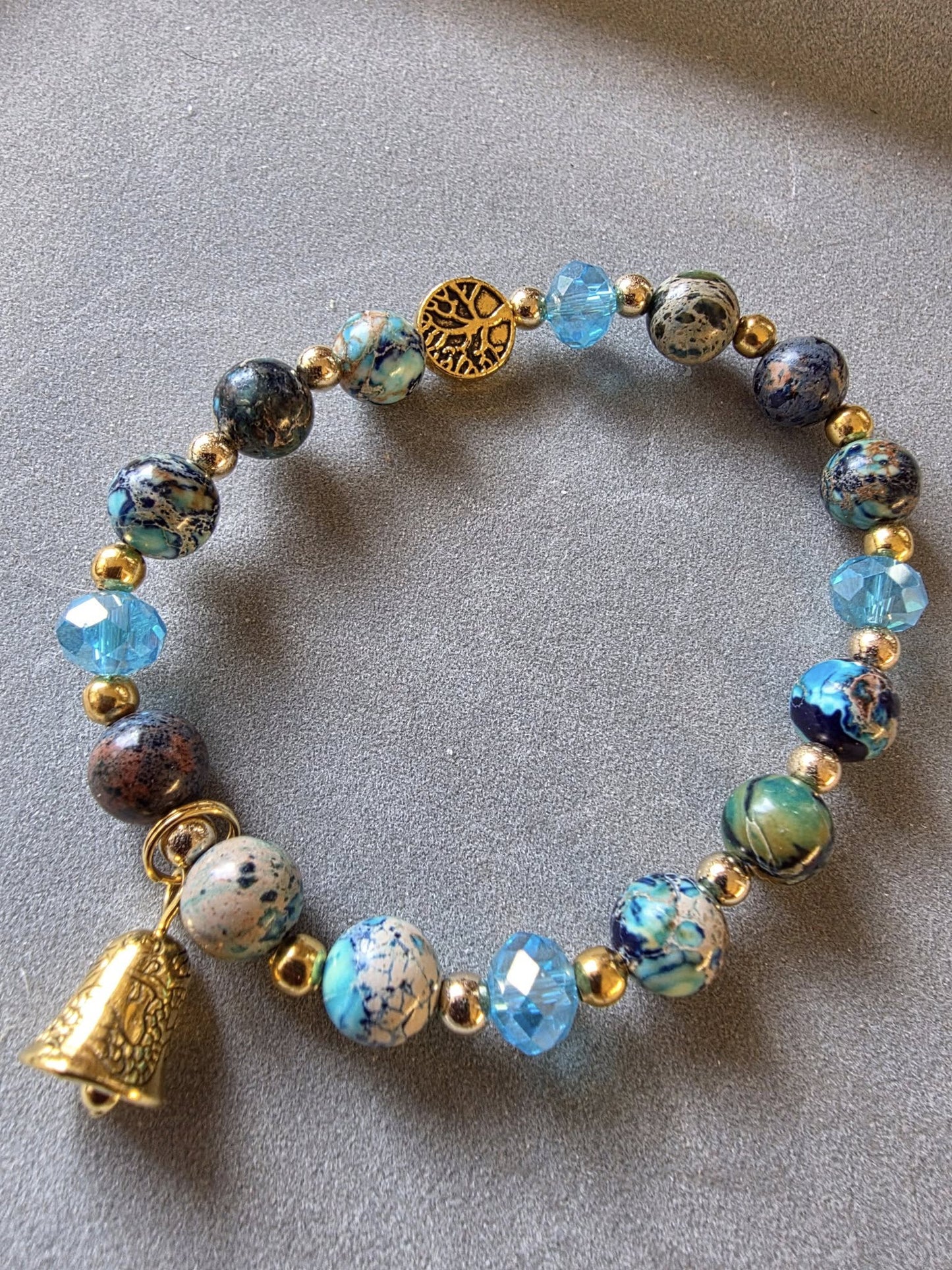 Gros plan sur le bracelet en pierre protectrice de LhanisaCréa, affichant ses motifs mystiques comme l'Arbre de Vie et les Triple Lunes, parfait pour un style élégant.