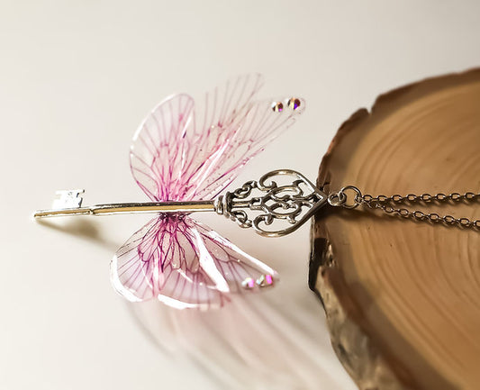 Détail du collier Souffle Féerique, montrant les Ailes de Fées artisanales en cellulose, ornées de paillettes irisées.