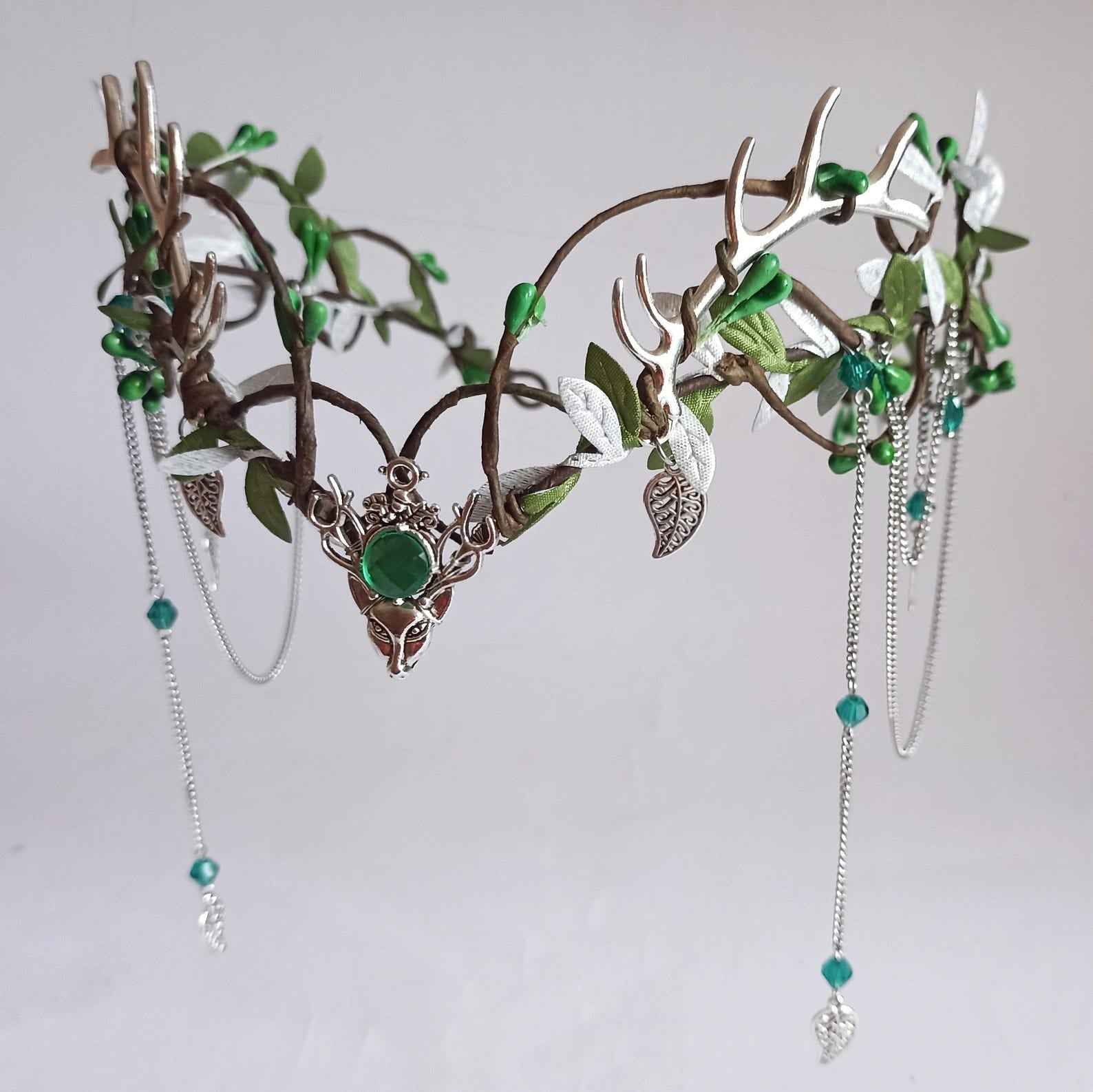Coiffe de cerf argenté Couronne de bois Diadème de l'enseigne Etsy, un accessoire féerique exquis, ornée de délicates feuilles scintillantes et d'une pierre précieuse verte, parfaite pour le cosplay ou les occasions spéciales.