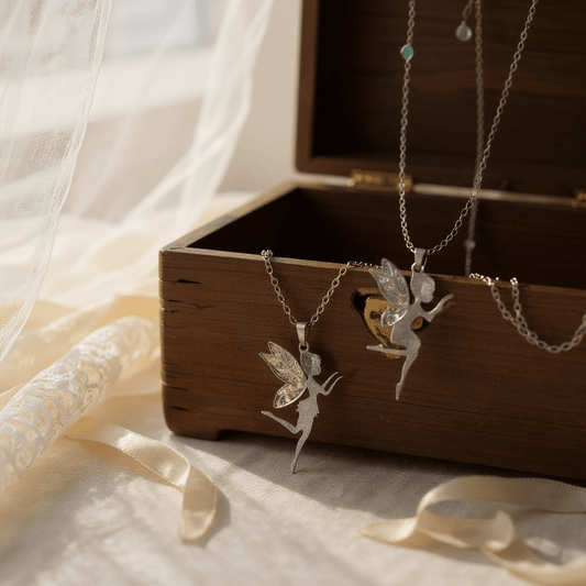 Collier fée élégant en acier inoxydable avec cristaux Swarovski, conçu par Jessica Deelyah, illuminant chaque mouvement avec des ailes colorées et une touche de magie.