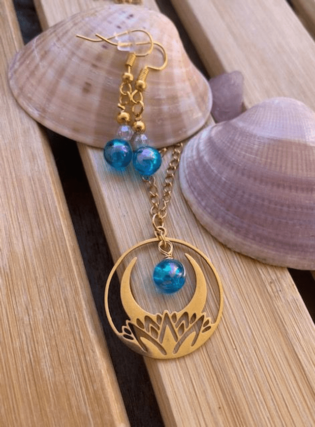 Collier lotus et lune - Bleu holographique AB de Jessica Deelyah, un bijou élégant capturant l'éclat mystique de la lune et la délicatesse du lotus, parfait pour vos tenues.