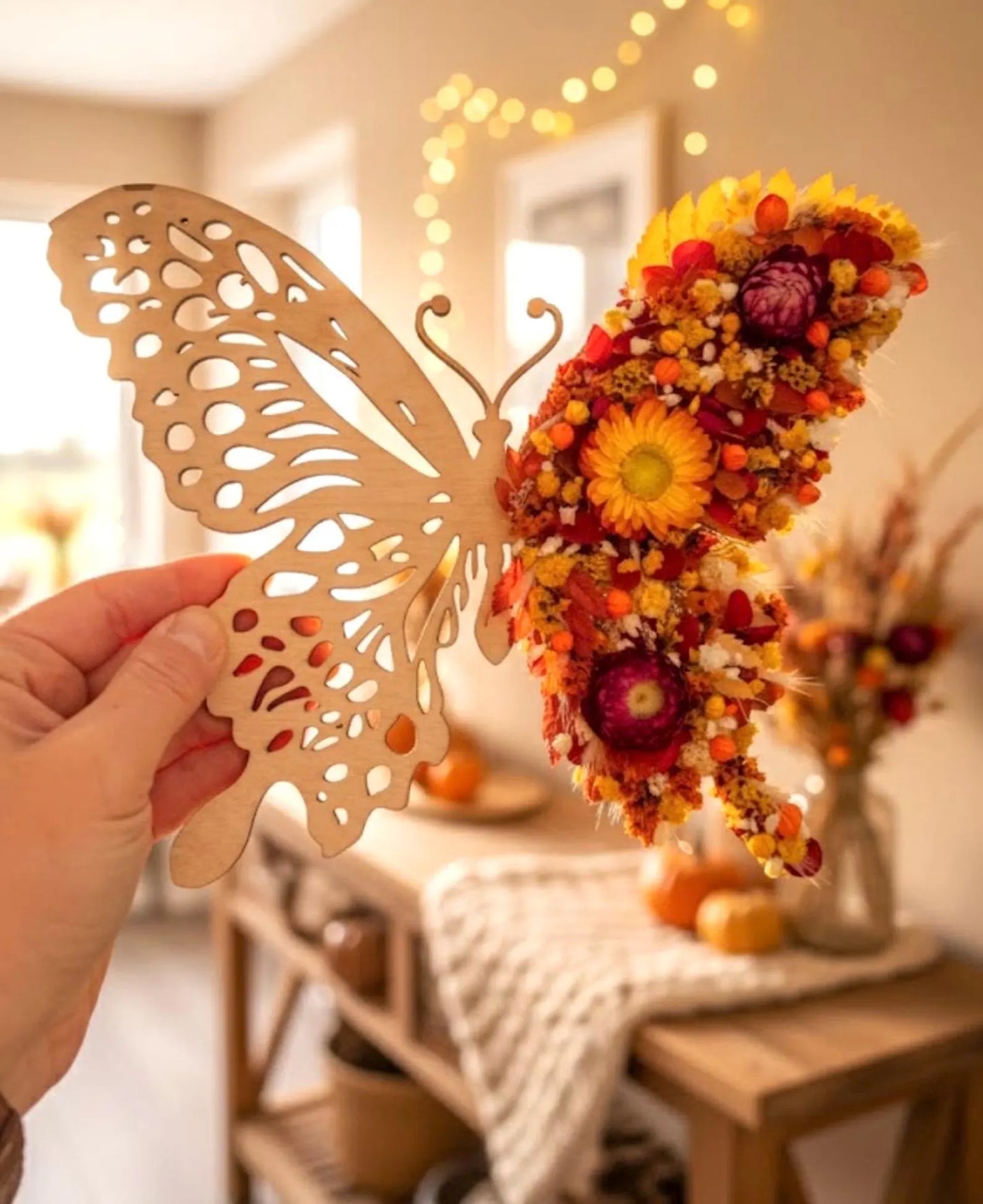 Papillon en bois décoratif de L'atelier Bcréa, ornée de fleurs séchées, apportant une touche naturelle à votre intérieur.