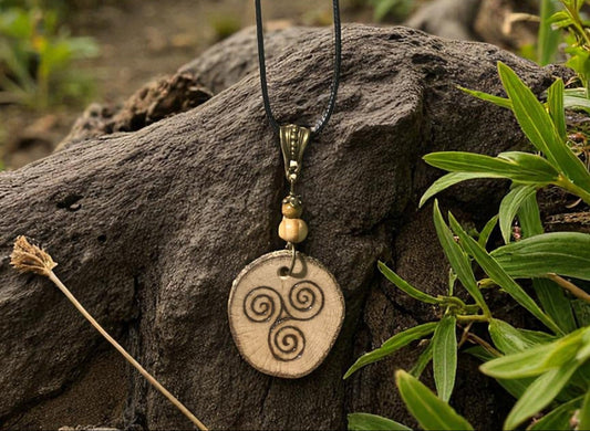 Pendentif Triskell de Faërie en bois naturel, symbole de mystère et de beauté, fait main et inspiré par les légendes bretonnes.