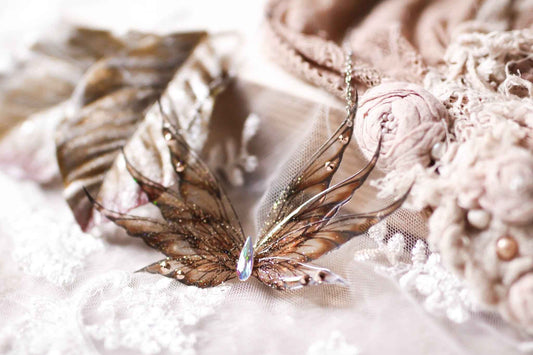 Collier Plume de Griffon de Faërie avec des ailes de fées en dégradé doré, orné de paillettes irisées et strass scintillants, capturant la lumière avec une navette en cristal Swarovski.