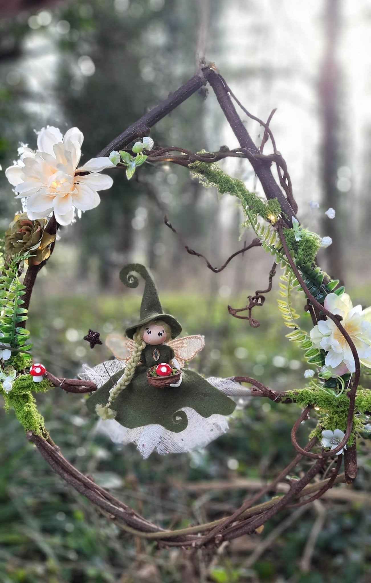 Suspension féerique lumineuse de La Fée Bidouille, une couronne décorative apportant une ambiance magique à votre intérieur avec sa guirlande intégrée et son design baroque.