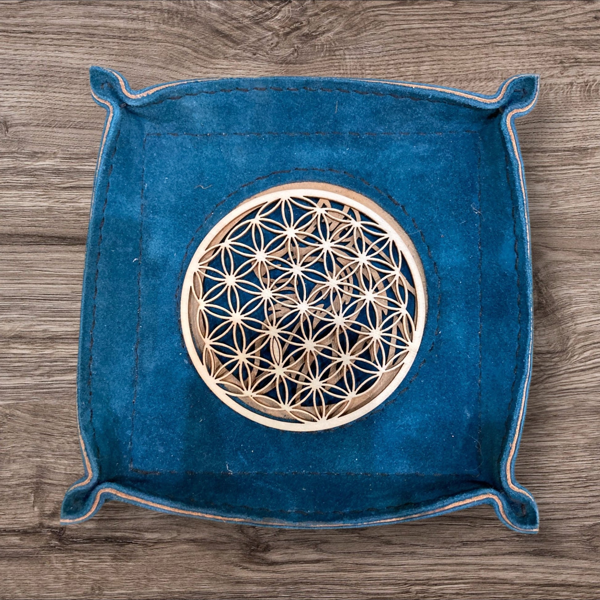 Inspirant vide-poches en cuir et bois par Eric Cuir, orné d'un médaillon au symbolisme apaisant.