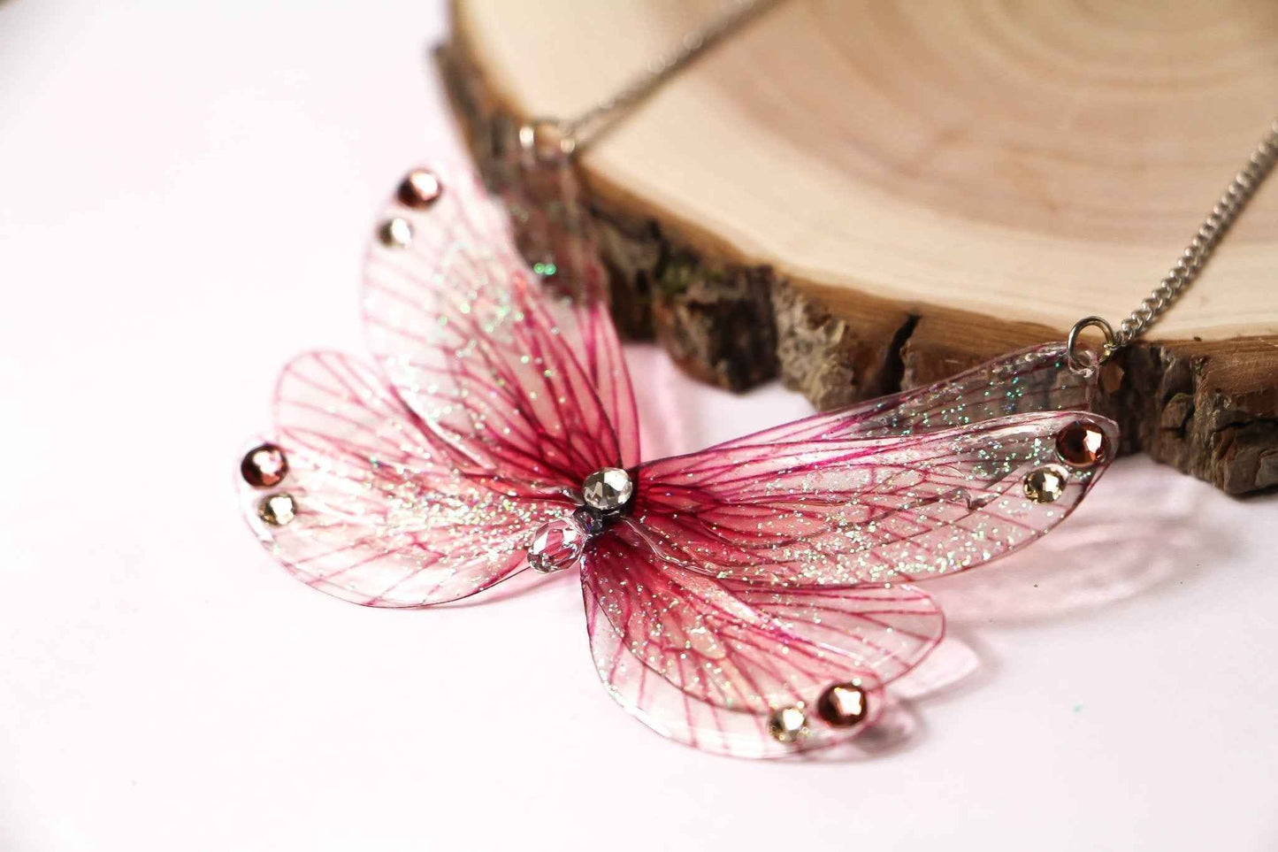 Collier Vœux Oublié de Faërie, avec des ailes de nymphe en violet et cristaux Swarovski, révélant une magie intemporelle et une élégance fascinante.