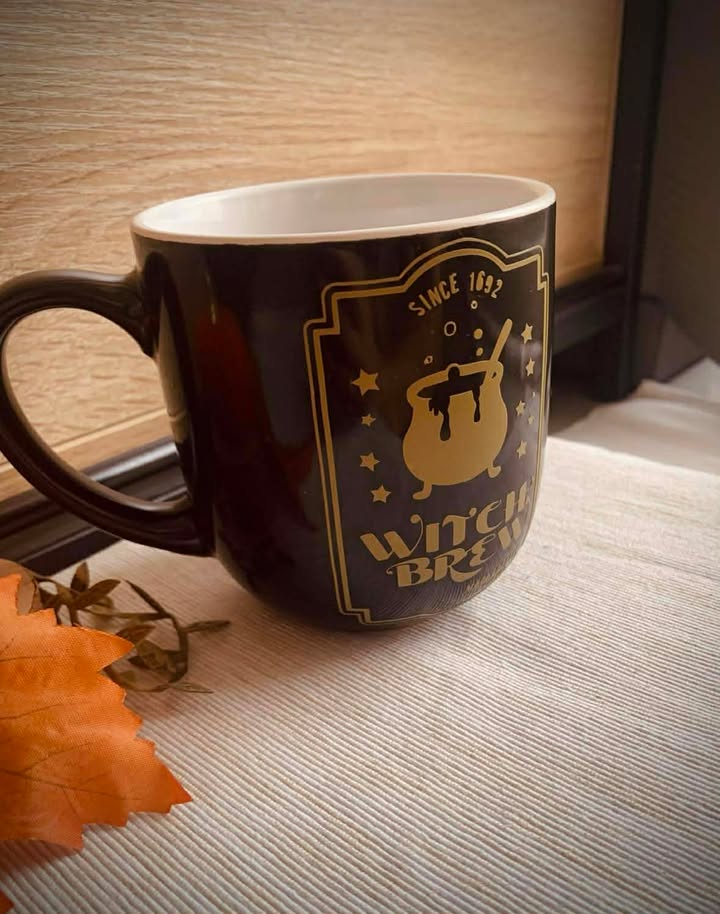 Tasse chaudron doré witchy par Jessica Deelyah, avec un design féerique et mystérieux, idéale pour savourer vos boissons préférées.
