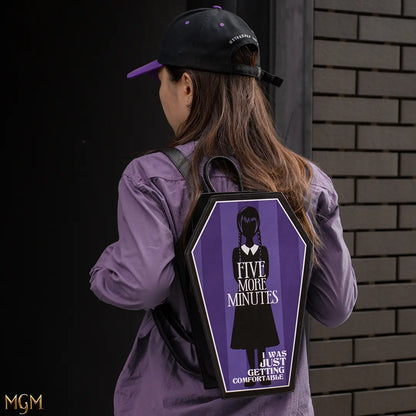 Sac à dos cercueil - Wednesday, porté par un jeune adulte montrant sa capacité de rangement généreuse et son allure gothique chic, un must pour les fans.