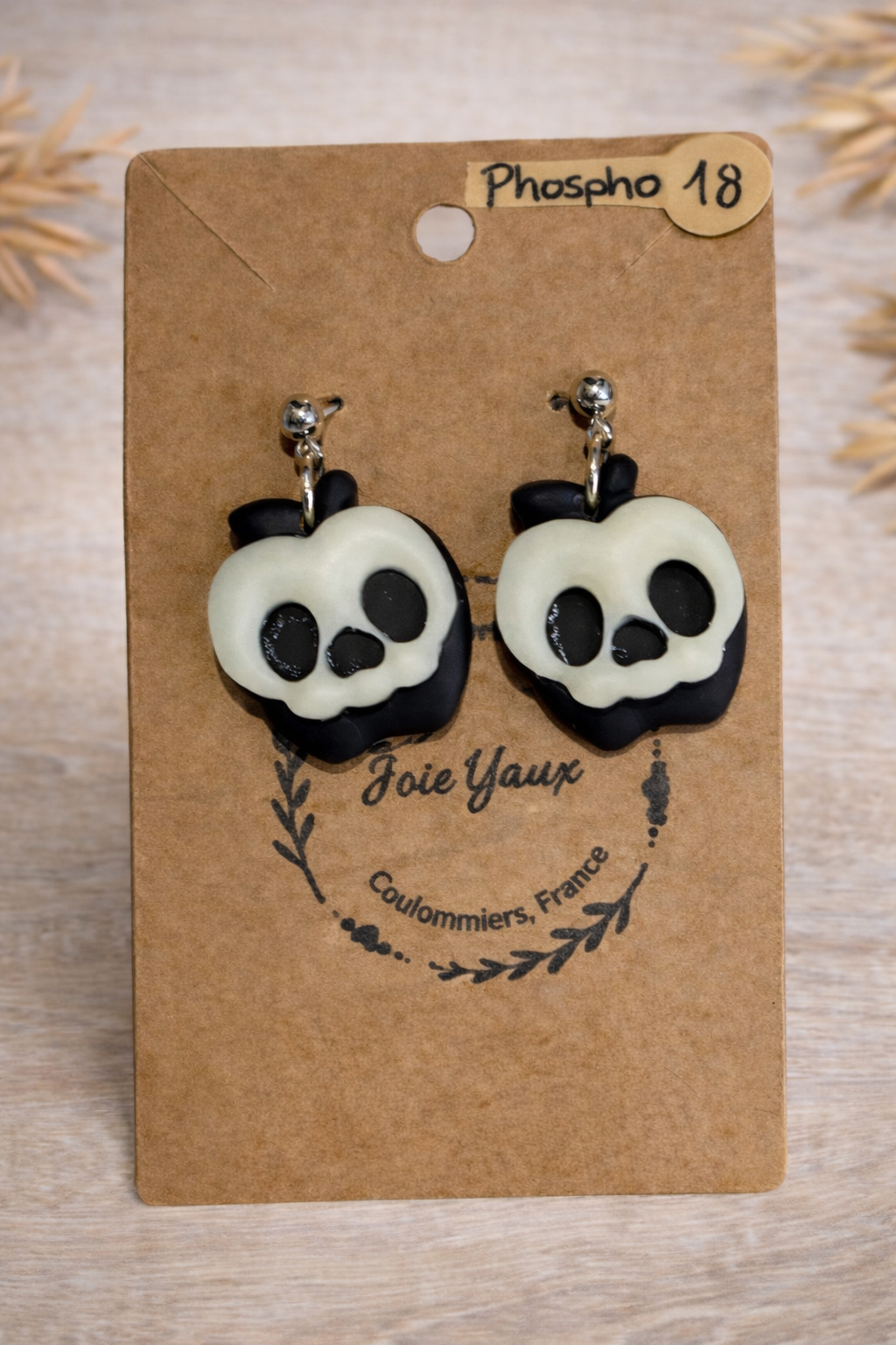 Boucles d’oreilles Pomme empoisonnée de Jessica Deelyah, artisanat en argile polymère et résine, avec effet phosphorescent captivant.