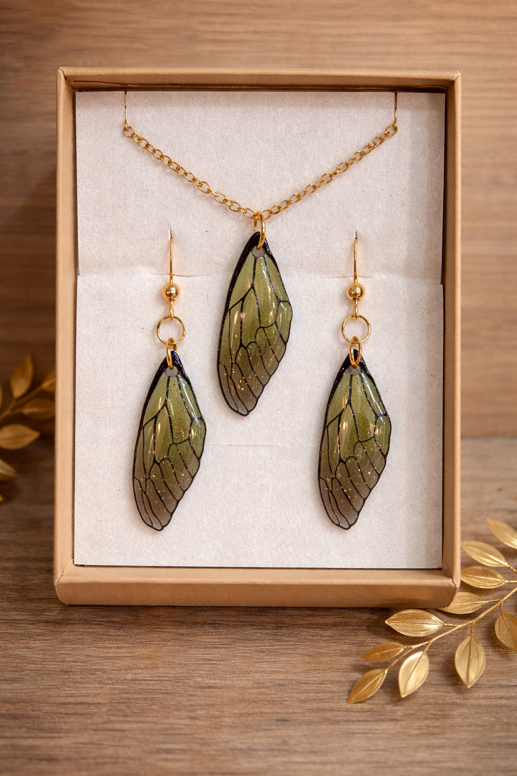 Ensemble collier et paire de boucles d’oreilles - Ailes de Fées, montrant un collier éblouissant avec des reflets bleutés et des détails enchanteurs, parfait pour un look féerique.