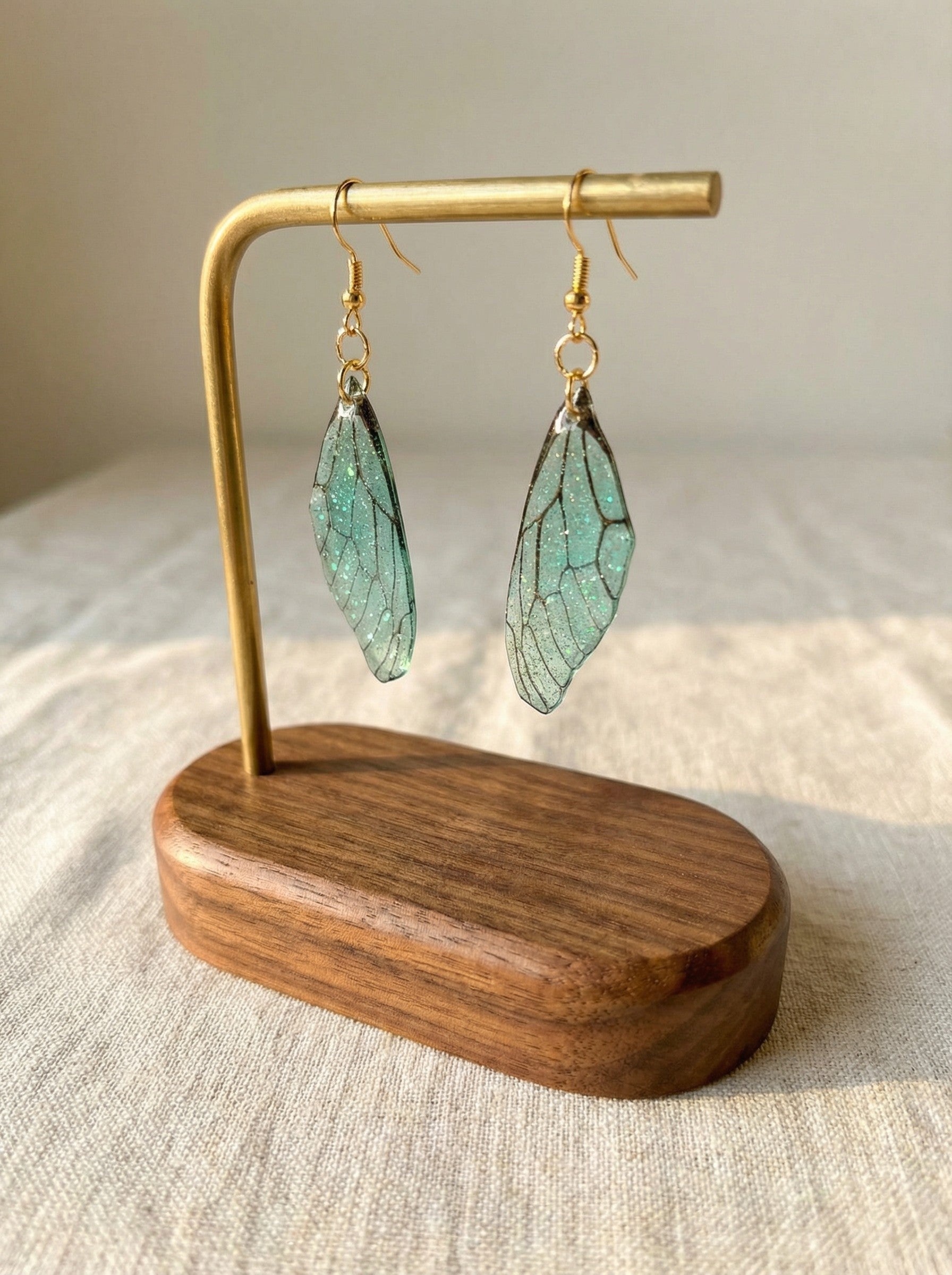 Boucles d’oreilles Ailes de Nymphe – Vert d’Eau Scintillant, artisanales et scintillantes, évoquant la légèreté et l'élégance avec leur design inspiré de la nature.