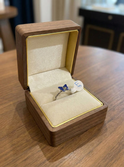 Bague artisanale simple « Bouton de Nature » avec un délicat cabochon fleuri, mise en valeur sur un fond naturel.