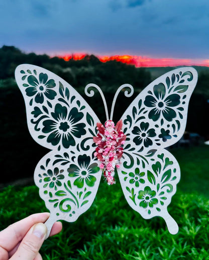 Papillon en bois avec une aile recouverte de fleurs séchées de L'atelier Bcréa, une œuvre artisanale unique qui apporte une touche de poésie à votre décoration.