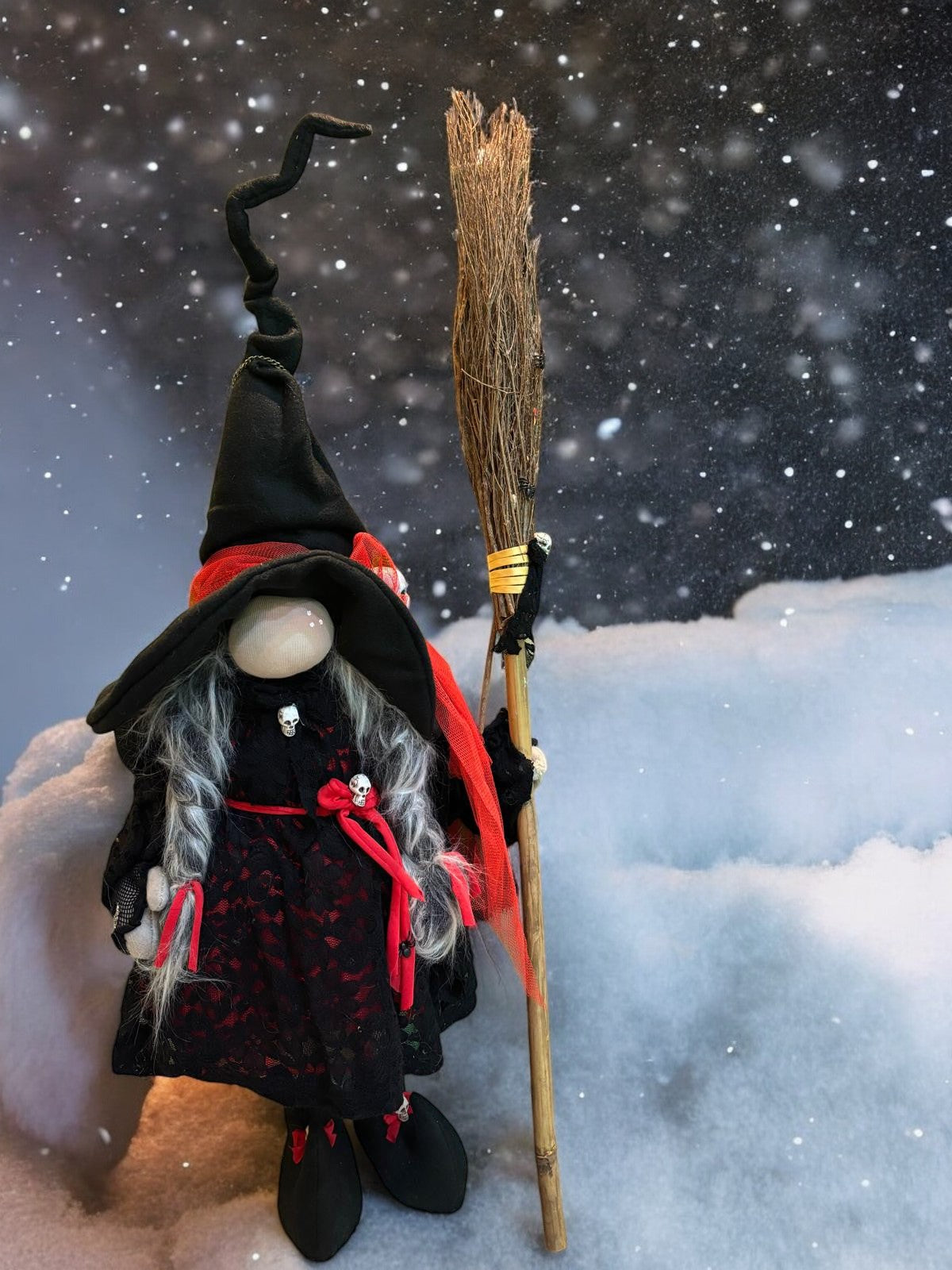 Gnome Petite Sorcière Rouge avec sa robe noire brodée et balai traditionnel, un accessoire artisanal apportant magie et charme à votre décoration intérieure.