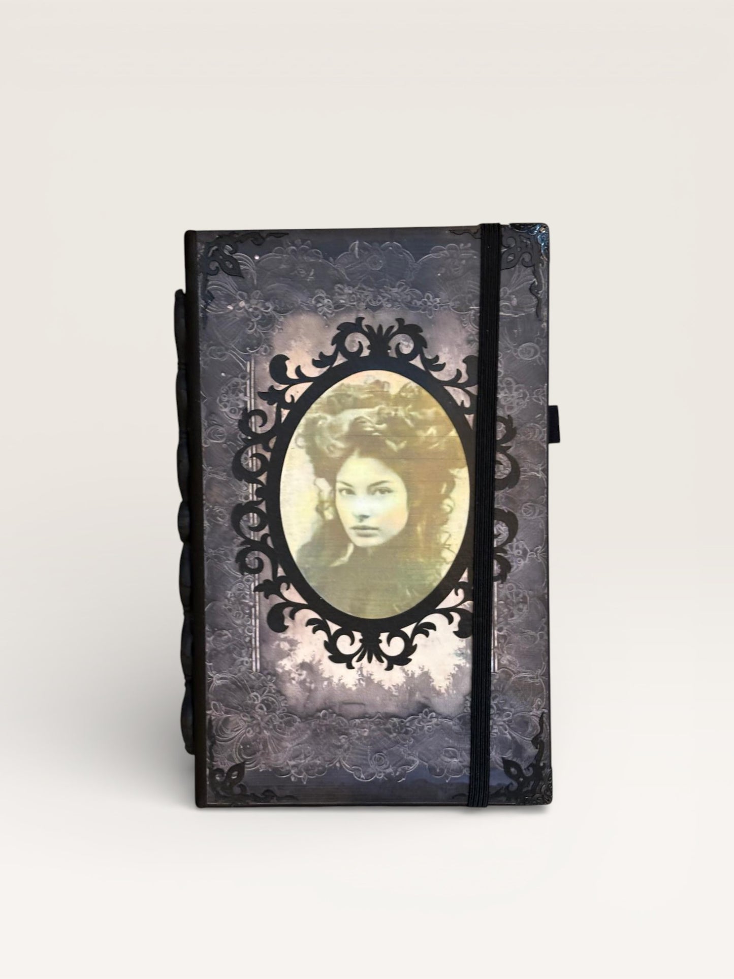 Carnet Portrait : Une couverture de carnet élégante présentant un visage ancien entouré d'un cadre ornemental, symbole d'introspection.