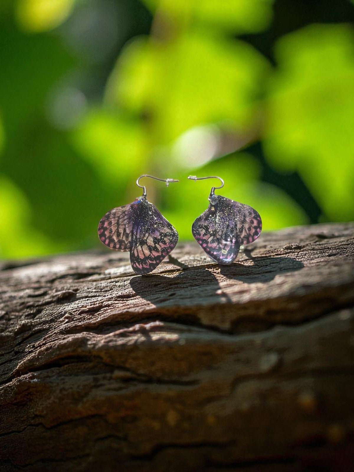 Boucles d'oreilles Ailes d’Améthyste de la marque Faërie, présentant des ailes translucides qui capturent la lumière avec une touche magique et féerique.