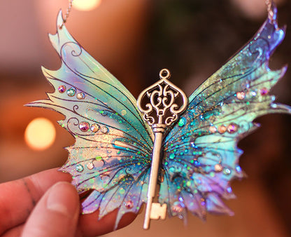 Collier 'Dragon de l'Hiver Glacé' par Faërie, présentant des Ailes de Fée bleues et violettes, parsemées de paillettes iridescentes et de strass Swarovski.