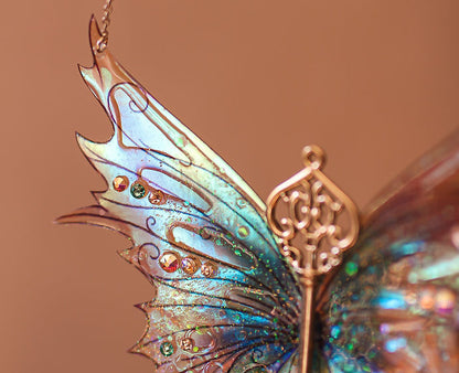 Détail du collier 'Dragon de l'Hiver Glacé', mettant en valeur les Ailes de Fée holographiques qui se transforment en arc-en-ciel à la lumière.