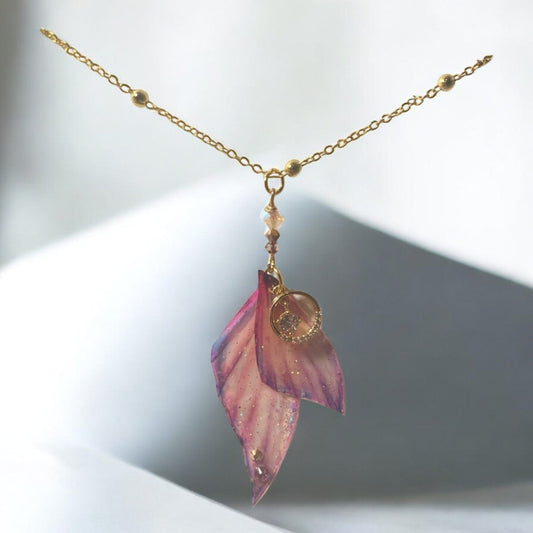 Collier ailé fascinant de Faërie, présentant des ailes rose violacé scintillantes et des strass Swarovski, une pièce d'art magique faite main.