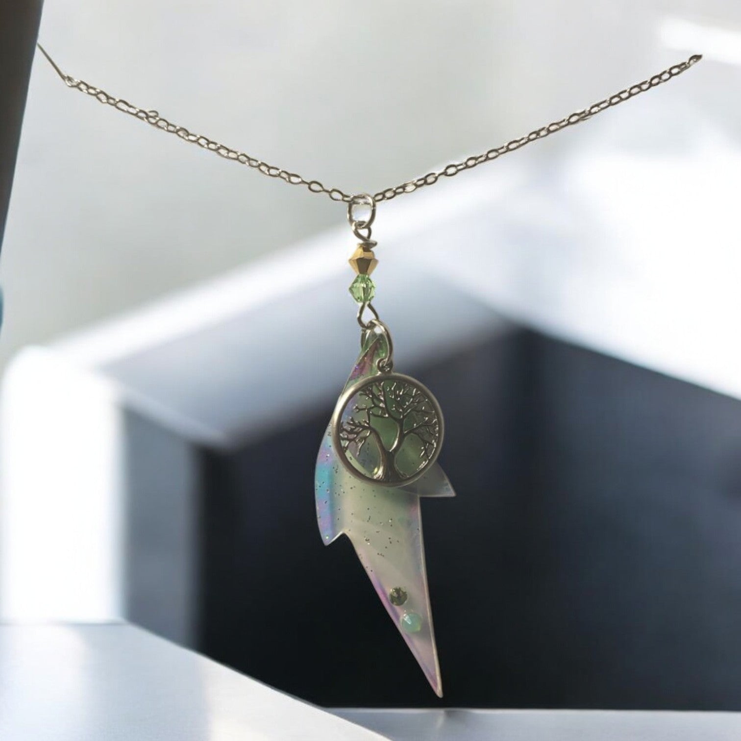 Collier Arbre de Vie de Faërie, un bijou enchanteur avec pendentif orné d'ailes de fée en dégradé de vert et perles Swarovski, symbolisant la magie et la connexion à la nature.