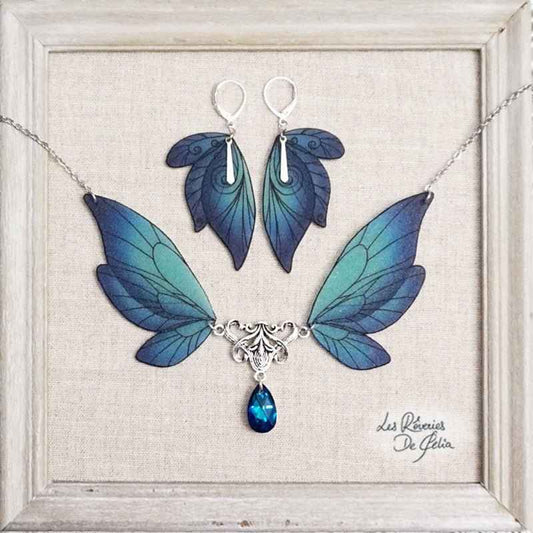 Collier Majestiel et boucles d'oreilles ailes de fée bleu, élégant bijou artisanal de Les Rêveries de Célia, scintillant avec des cristaux Swarovski et des nuances de bleu dégradé.