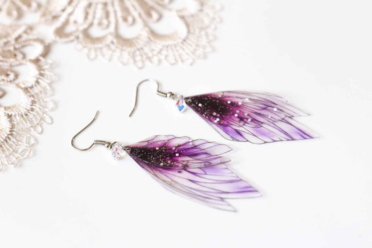 Bijou Élixir Féerique de Faërie : Ailes de Nymphe en dégradé violet scintillant avec paillettes iridescentes, confection artisanale en acier chirurgical inoxydable.