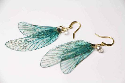 Boucles d’oreilles Fontaine d’Or de Faërie, ornées d’Ailes de Fée turquoise et d’un Cristal Swarovski, captivant l’attention avec éclat et élégance.