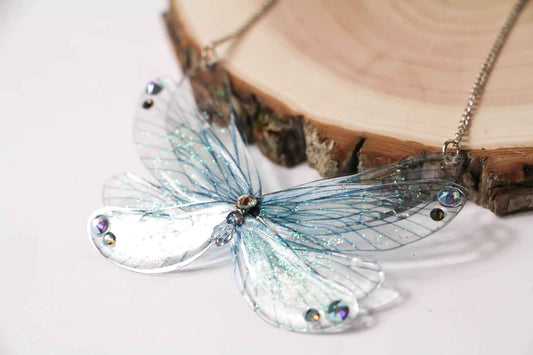 Collier Freyja de Faërie, élégant bijou aux Ailes de Fées en bleu glacé, parfait pour une soirée féerique ou un look quotidien enchanteur.