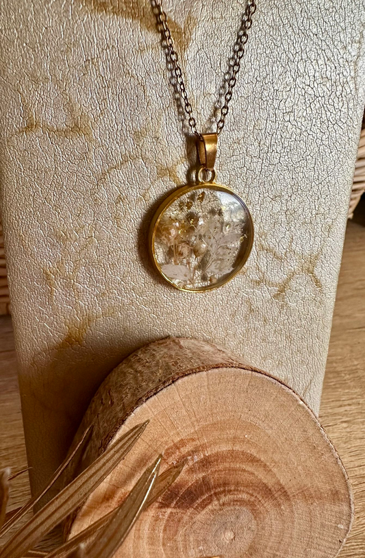 Détails du collier résine fleurs feuilles d’or, mettant en valeur les fleurs séchées authentiques et l'artisanat inspiré par la nature.