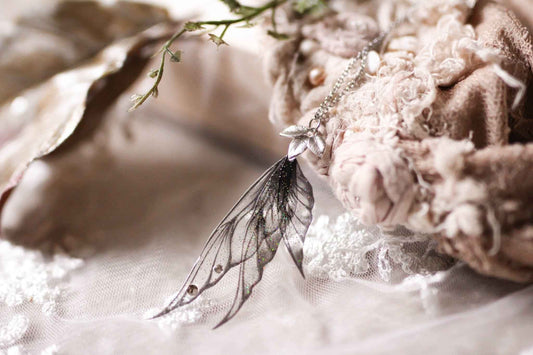 Collier Larme Spectrale de Faërie, un bijou rassembleur de magie avec des ailes de fées noires scintillantes.