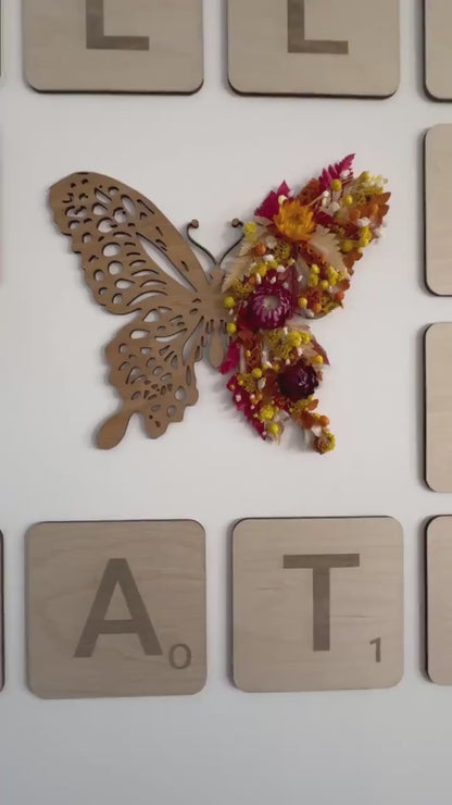 Wooden butterfly with a wing covered with dried flowers