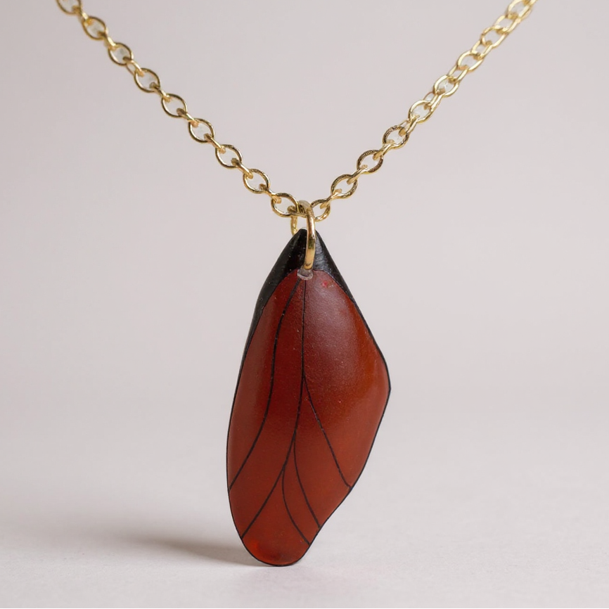 Collier pendentif Aile de fée, bijou artisanal unique, avec une aile stylisée en gros plan, capturant la magie et la délicatesse.
