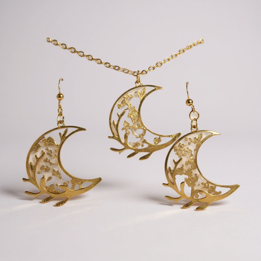 Ensemble collier et paire de boucles d’oreilles - Lune d’Or Florale, présentant un collier délicat en acier inoxydable doré accompagné de croissants de lune ornés de motifs floraux.