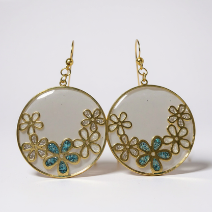Boucles d’oreilles Fleurs de Rosée Dorée, artisanat fait main avec fleurs dorées et nuances de bleu, élégantes et délicates.