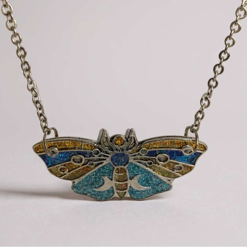 Collier pendentif « Papillon Mystique des Lunes » - un bijou en forme de papillon de nuit, orné de bleu, doré et turquoise, idéal pour une touche d'élégance nocturne.