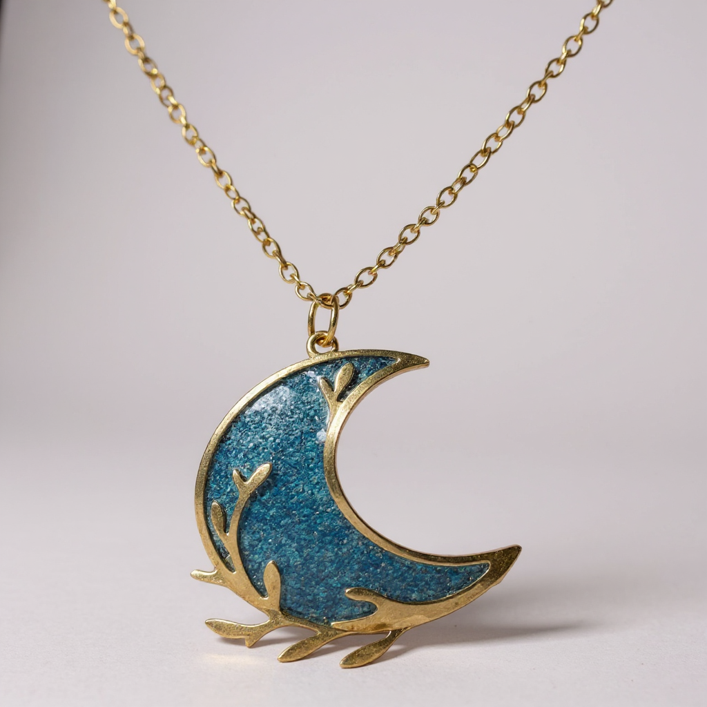 Détail artisanal du collier pendentif - Lune, mettant en avant la finesse du design et la brillance du cabochon dans un cadre fait main.