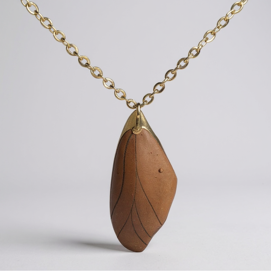 Le collier pendentif Aile de fée porté, ajoutant une touche de charme et d'originalité à un style personnel.