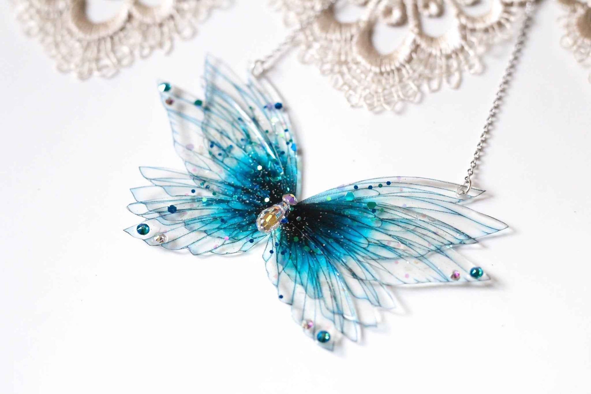 Collier Songe Boréal de Faërie, bijou délicat avec des ailes de nymphe ornées de paillettes artisanales et d'un cristal Swarovski, parfait pour illuminer vos tenues.