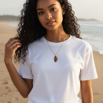 Collier pendentif Aile de fée présenté sur un fond artistique, soulignant son charme unique et son artisanat local.